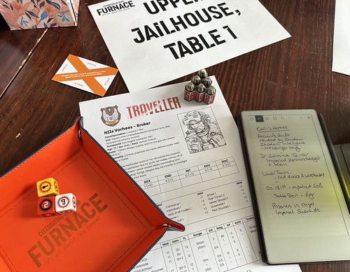An image of my orange Furnace dice tray (with three official Traveller dice), the Traveller character sheet for Nils Vorhees with 6 bullet dice on it,  and a reMarkable Paper Pro Move being used for notes. The table number, a box of tissues and an X-card are at the top of the image.