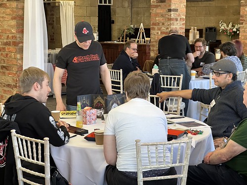 A game of Mork Borg with the players enjoying themselves and the GM celebrating his being from Scotland with a T-shirt saying Thank Fuck I'm Scottish.